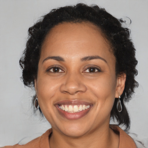 Joyful latino adult female with medium  black hair and brown eyes