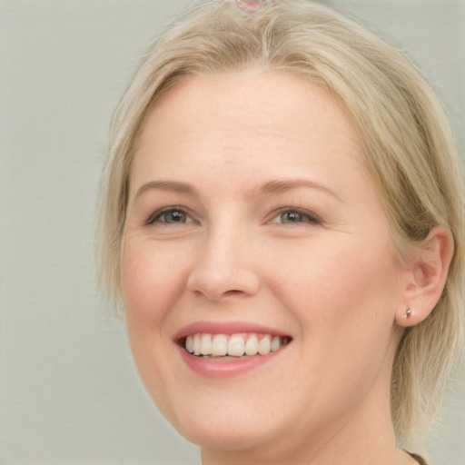 Joyful white young-adult female with long  blond hair and blue eyes