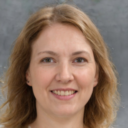 Joyful white adult female with medium  brown hair and grey eyes