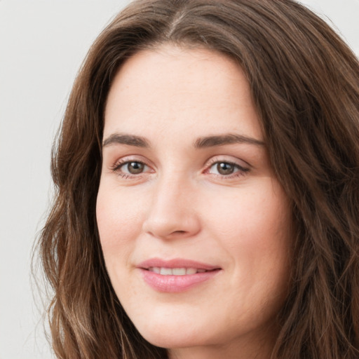 Joyful white young-adult female with long  brown hair and green eyes