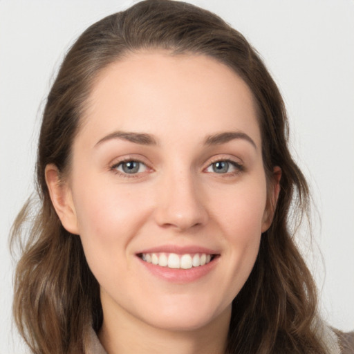 Joyful white young-adult female with long  brown hair and grey eyes