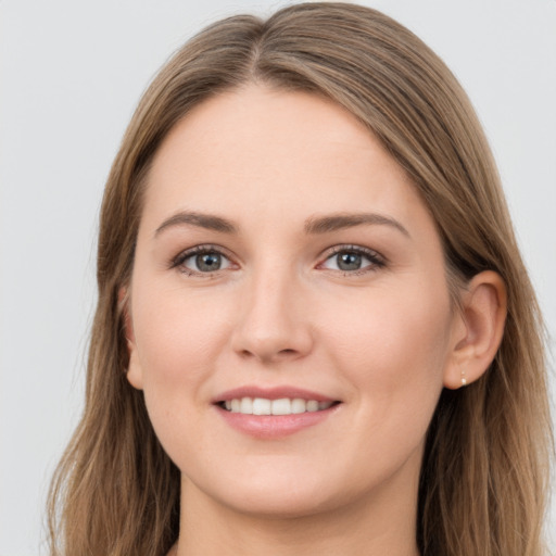 Joyful white young-adult female with long  brown hair and grey eyes