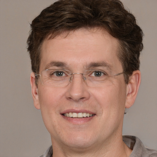 Joyful white adult male with short  brown hair and grey eyes