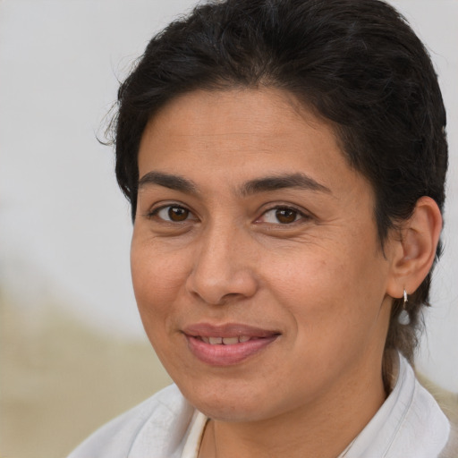 Joyful latino adult female with short  brown hair and brown eyes