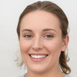 Joyful white young-adult female with medium  brown hair and blue eyes