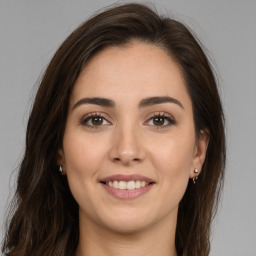 Joyful white young-adult female with long  brown hair and brown eyes