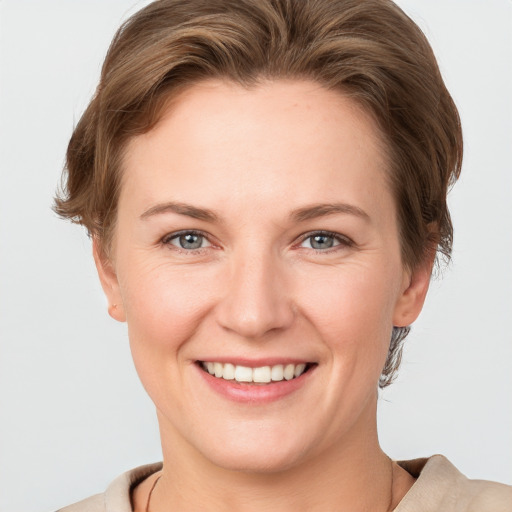 Joyful white young-adult female with short  brown hair and grey eyes