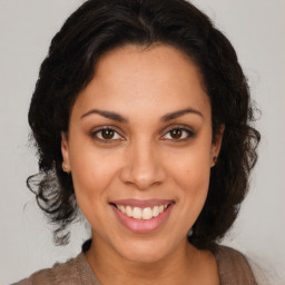 Joyful latino adult female with medium  brown hair and brown eyes