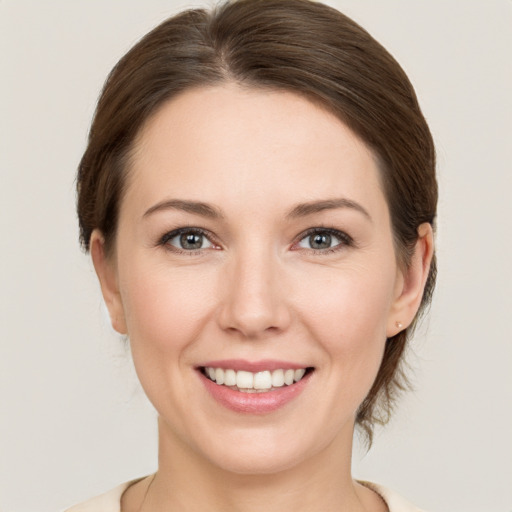 Joyful white young-adult female with medium  brown hair and grey eyes