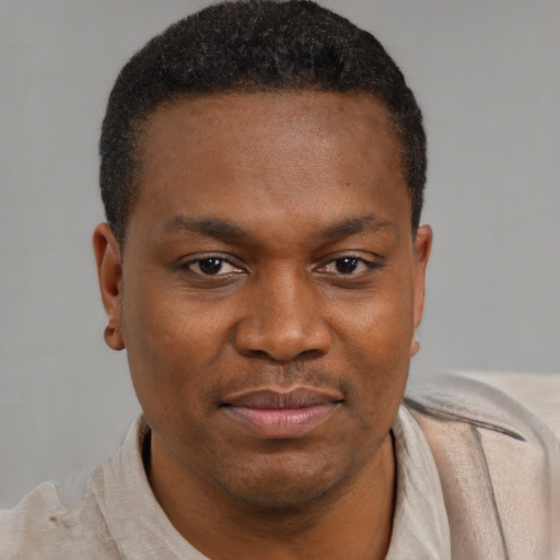 Joyful black young-adult male with short  brown hair and brown eyes