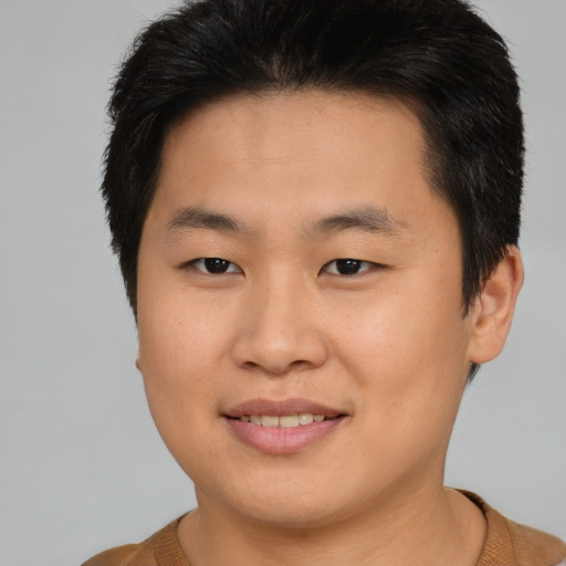 Joyful asian young-adult male with short  brown hair and brown eyes