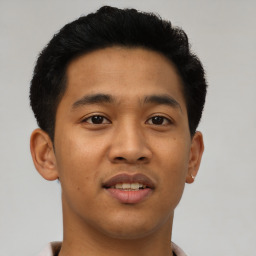 Joyful latino young-adult male with short  brown hair and brown eyes