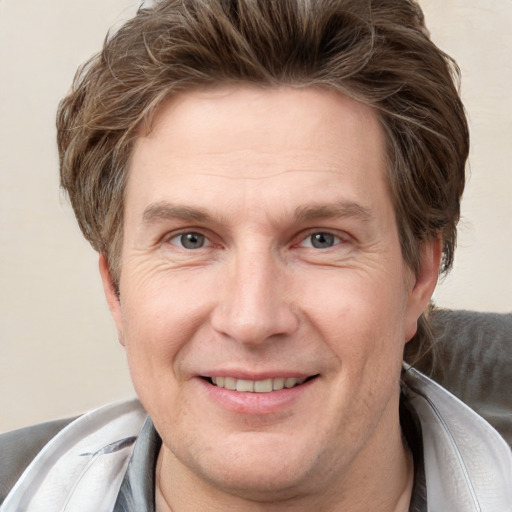 Joyful white adult male with short  brown hair and grey eyes