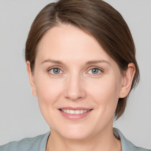 Joyful white young-adult female with medium  brown hair and grey eyes