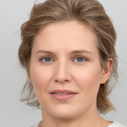 Joyful white adult female with medium  brown hair and grey eyes