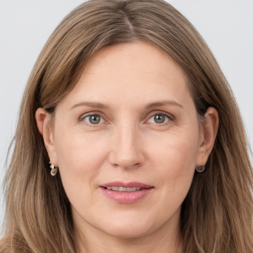 Joyful white adult female with long  brown hair and grey eyes