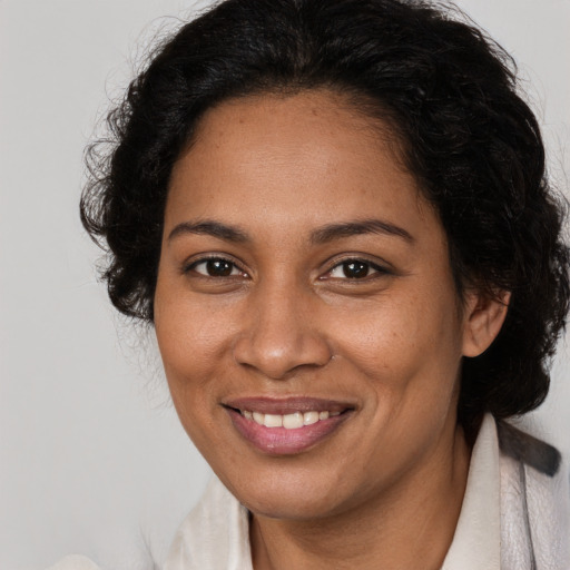 Joyful black adult female with medium  brown hair and brown eyes