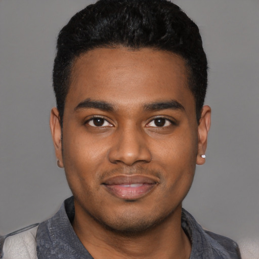 Joyful black young-adult male with short  black hair and brown eyes