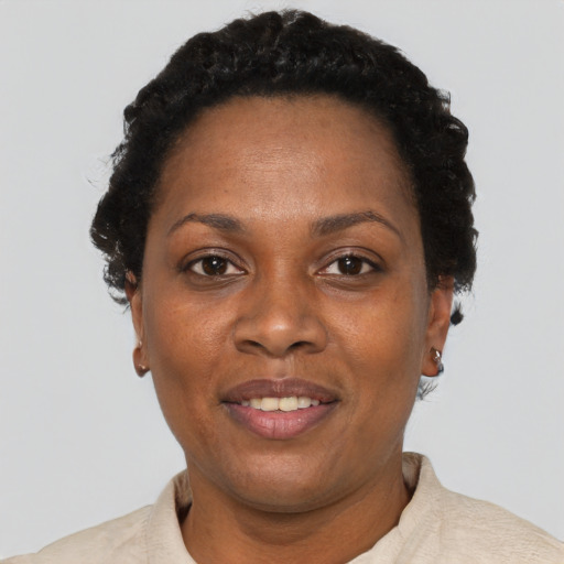 Joyful black adult female with short  black hair and brown eyes