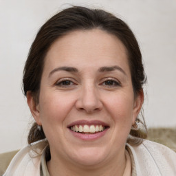 Joyful white adult female with medium  brown hair and blue eyes