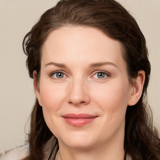 Joyful white young-adult female with long  brown hair and green eyes