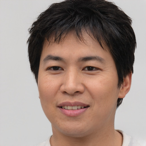 Joyful asian young-adult male with short  brown hair and brown eyes