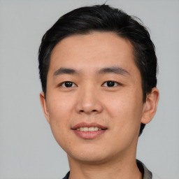 Joyful asian young-adult male with short  black hair and brown eyes