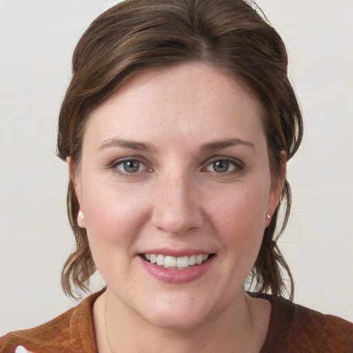 Joyful white young-adult female with medium  brown hair and blue eyes