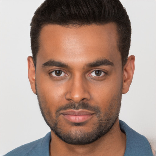 Joyful black young-adult male with short  brown hair and brown eyes