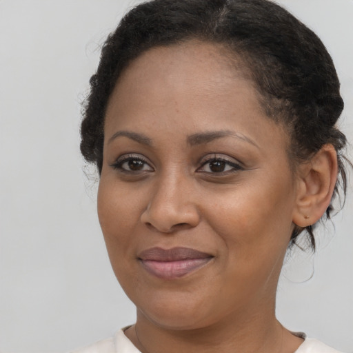 Joyful black young-adult female with medium  brown hair and brown eyes