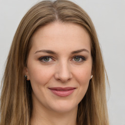 Joyful white young-adult female with long  brown hair and green eyes