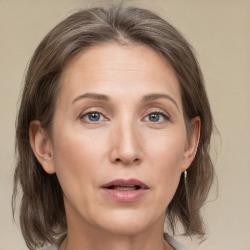 Joyful white adult female with medium  brown hair and grey eyes