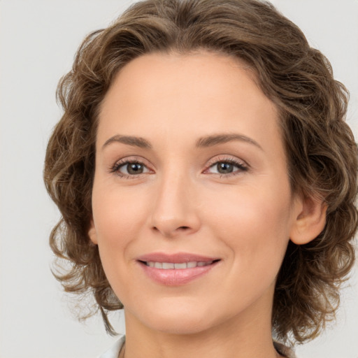 Joyful white young-adult female with medium  brown hair and green eyes