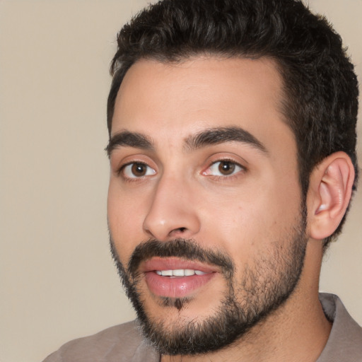 Joyful white young-adult male with short  black hair and brown eyes