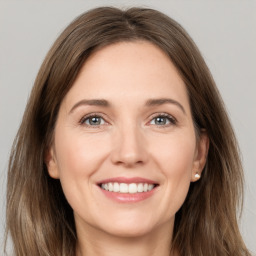 Joyful white young-adult female with long  brown hair and grey eyes