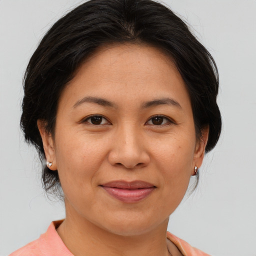 Joyful asian adult female with medium  brown hair and brown eyes