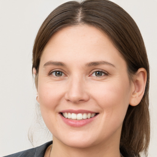 Joyful white young-adult female with medium  brown hair and grey eyes