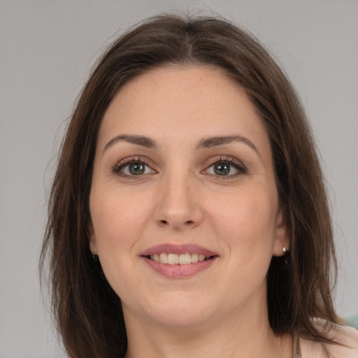 Joyful white young-adult female with long  brown hair and grey eyes