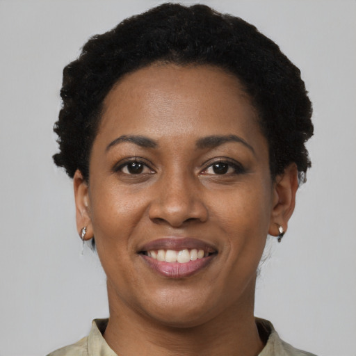 Joyful black young-adult female with short  black hair and brown eyes