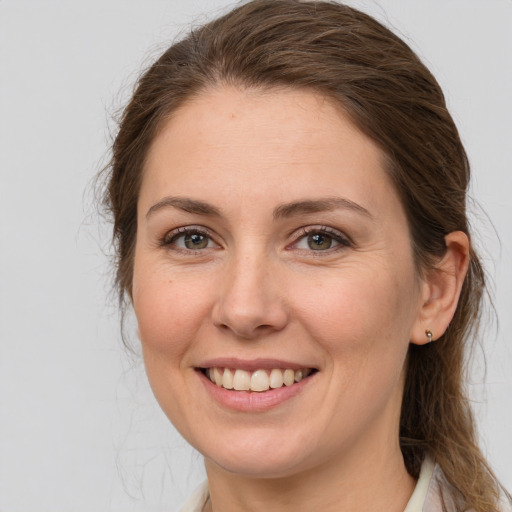 Joyful white young-adult female with long  brown hair and grey eyes