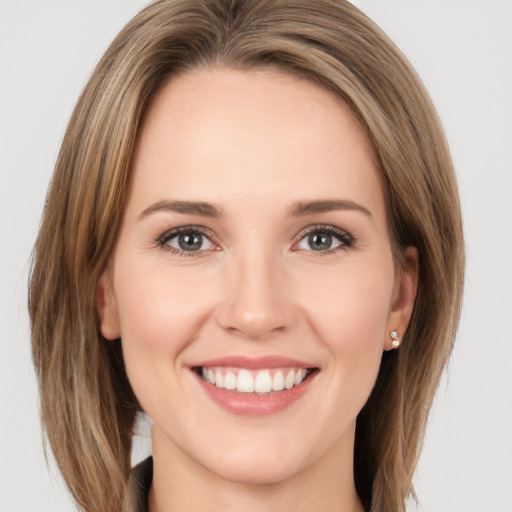 Joyful white young-adult female with medium  brown hair and green eyes