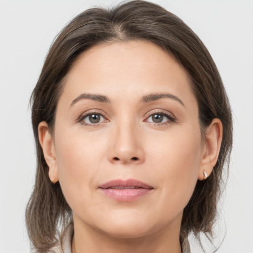 Joyful white young-adult female with medium  brown hair and grey eyes