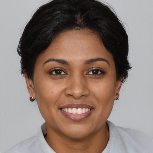 Joyful black young-adult female with medium  brown hair and brown eyes