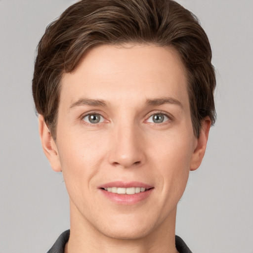 Joyful white young-adult male with short  brown hair and grey eyes