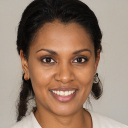 Joyful latino young-adult female with medium  brown hair and brown eyes