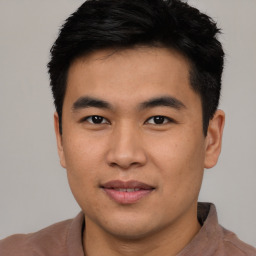 Joyful asian young-adult male with short  brown hair and brown eyes