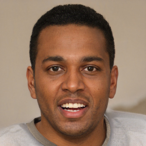 Joyful black young-adult male with short  black hair and brown eyes
