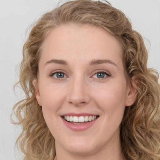 Joyful white young-adult female with long  brown hair and blue eyes