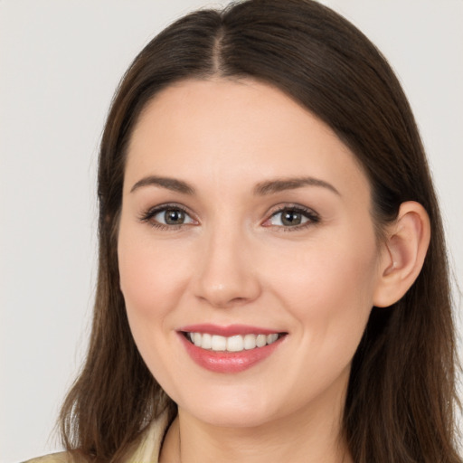 Joyful white young-adult female with long  brown hair and brown eyes