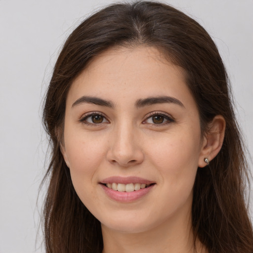 Joyful white young-adult female with long  brown hair and brown eyes